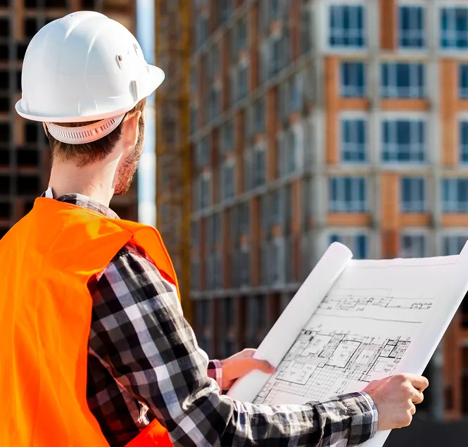 Bauleiter mit Bauplan auf der Baustelle